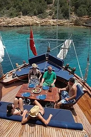 Trİppİn Yacht Photos Pics People relaxing on a 2006 Custom Wooden Ketch Tirhandil 20M yacht in clear turquoise waters.
