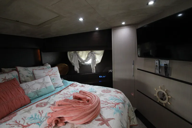  Yacht Photos Pics Luxurious bedroom interior of 2007 Uniesse 70 Sport yacht with elegant decor and ambient lighting.
