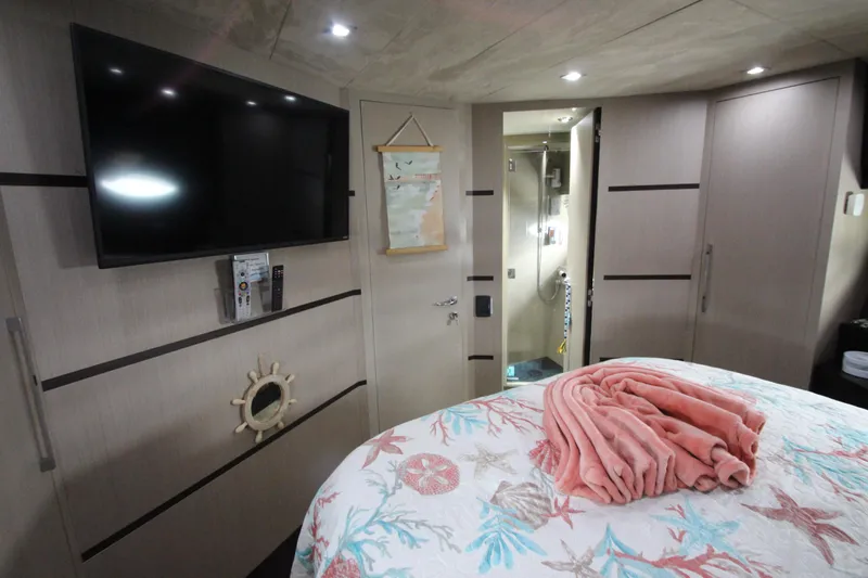  Yacht Photos Pics Luxurious 2007 Uniesse 70 Sport yacht bedroom with TV and nautical decor.