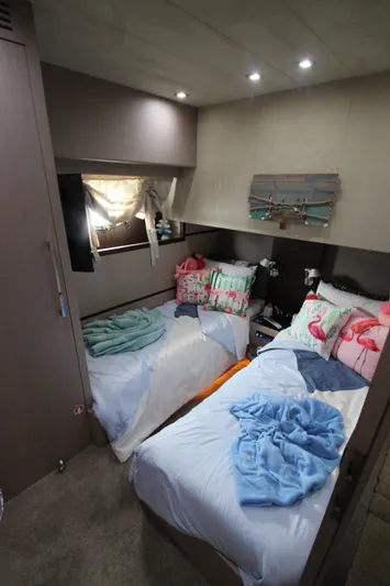  Yacht Photos Pics Cozy twin bedroom in 2007 Uniesse 70 Sport yacht with colorful pillows and soft lighting.