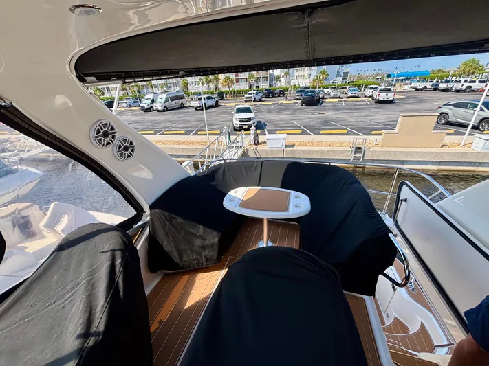  Yacht Photos Pics 2008 Sea Ray 44 Sedan Bridge yacht interior with covered seating and table, docked at marina.