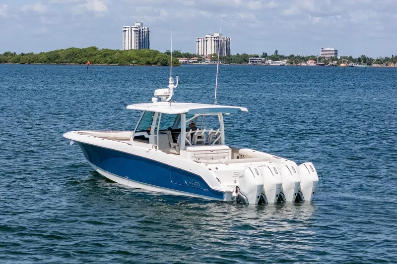  Yacht Photos Pics 2022 Boston Whaler 380 Outrage boat on calm water with cityscape background.