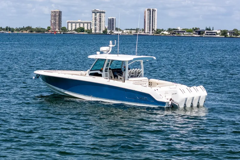 Yacht Photos Pics 2022 Boston Whaler 380 Outrage boat on water with city skyline in background.