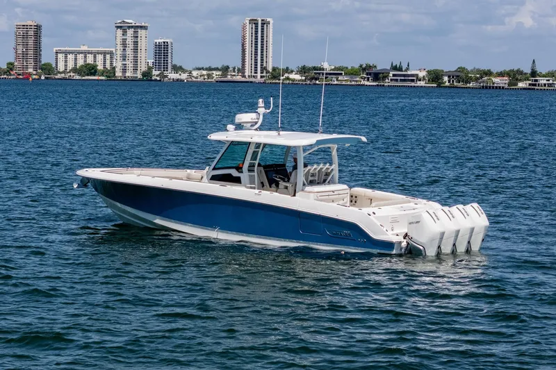  Yacht Photos Pics 2022 Boston Whaler 380 Outrage boat on water with city skyline in background.