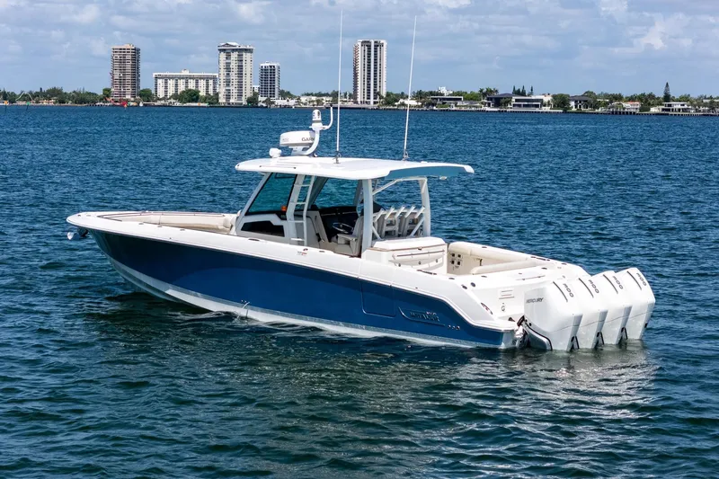  Yacht Photos Pics 2022 Boston Whaler 380 Outrage boat on water with city skyline background.
