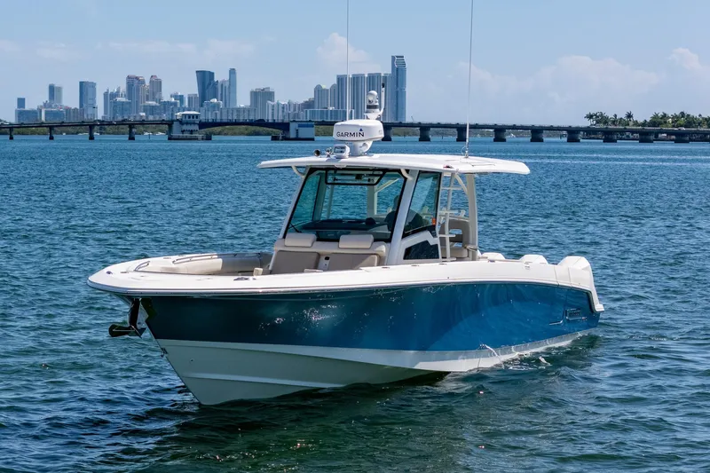  Yacht Photos Pics 2022 Boston Whaler 380 Outrage boat on water with city skyline background.