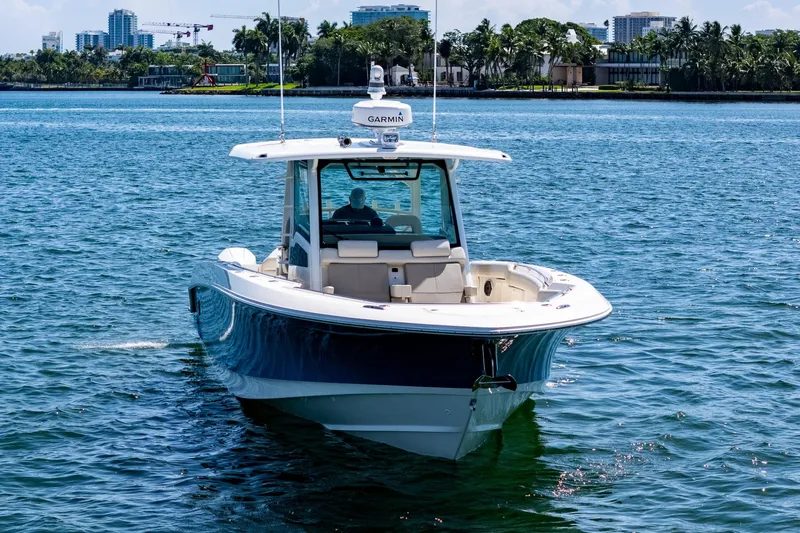  Yacht Photos Pics 2022 Boston Whaler 380 Outrage boat on water, with cityscape background.