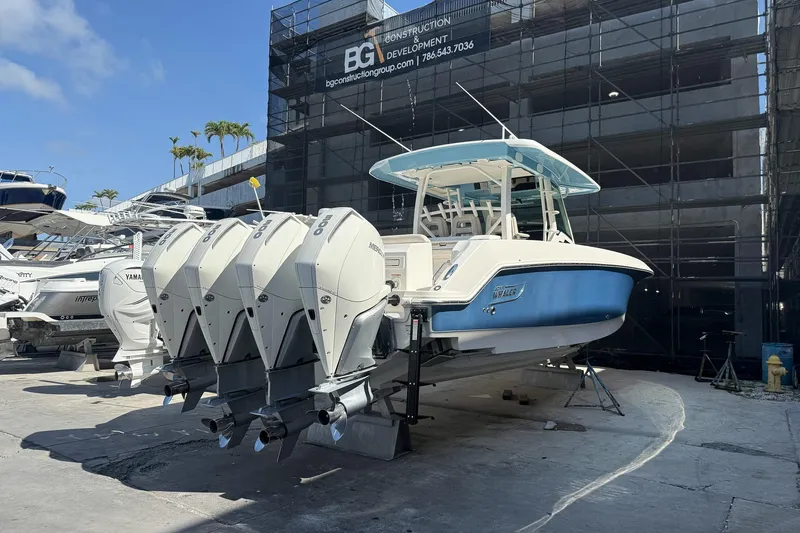  Yacht Photos Pics 2022 Boston Whaler 380 Outrage boat with four powerful outboard engines in a marina setting.