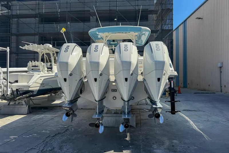  Yacht Photos Pics 2022 Boston Whaler 380 Outrage with four powerful outboard engines, docked in a marina.