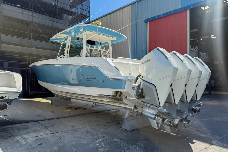  Yacht Photos Pics 2022 Boston Whaler 380 Outrage boat with four Mercury engines in a marina setting.