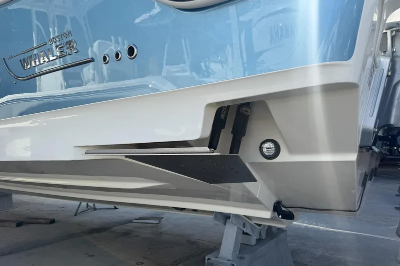  Yacht Photos Pics 2022 Boston Whaler 380 Outrage boat hull in light blue and white, docked.