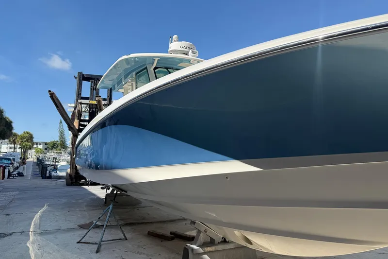  Yacht Photos Pics 2022 Boston Whaler 380 Outrage boat on dock under clear blue sky.