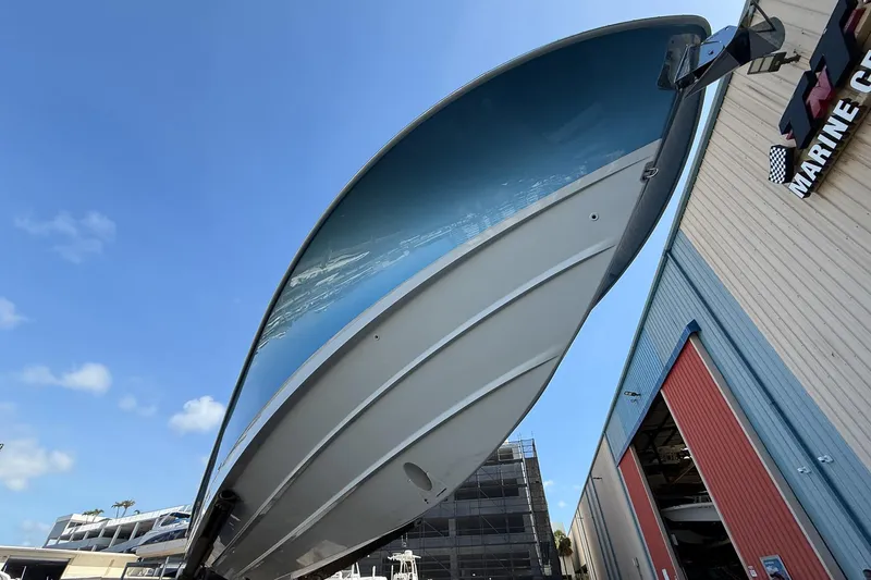  Yacht Photos Pics 2022 Boston Whaler 380 Outrage boat hull, viewed from below, near a marine facility.
