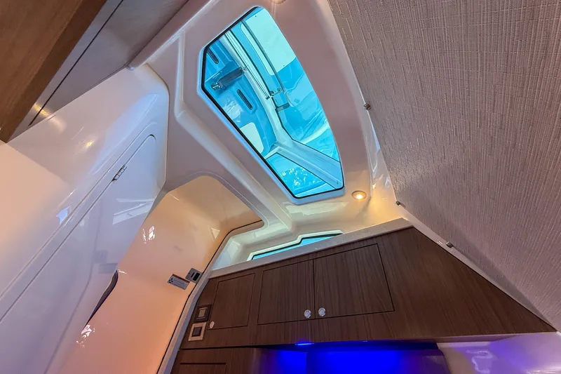  Yacht Photos Pics Interior view of 2022 Boston Whaler 380 Outrage cabin with skylight and wood cabinetry.
