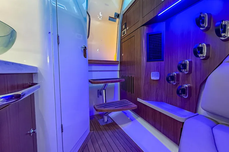  Yacht Photos Pics Interior of 2022 Boston Whaler 380 Outrage with modern wood finish and blue lighting.