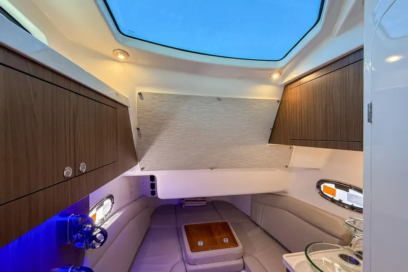  Yacht Photos Pics 2022 Boston Whaler 380 Outrage cabin interior with skylight, wood cabinets, and seating area.