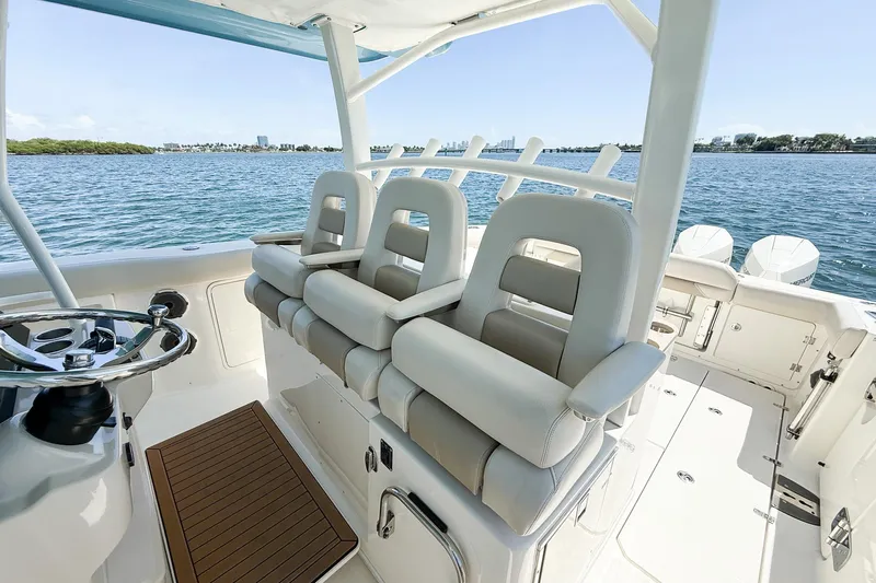  Yacht Photos Pics 2022 Boston Whaler 380 Outrage boat interior with helm seating and ocean view.