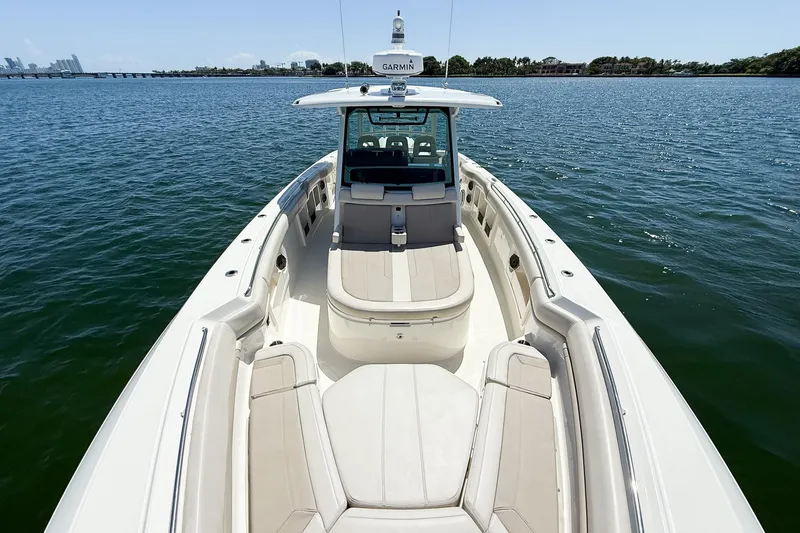 Yacht Photos Pics 2022 Boston Whaler 380 Outrage boat on calm water, showcasing spacious deck and seating.