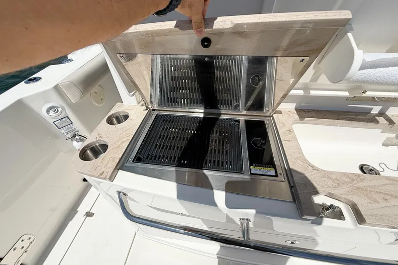  Yacht Photos Pics Outdoor grill on 2022 Boston Whaler 380 Outrage boat, featuring dual cup holders.