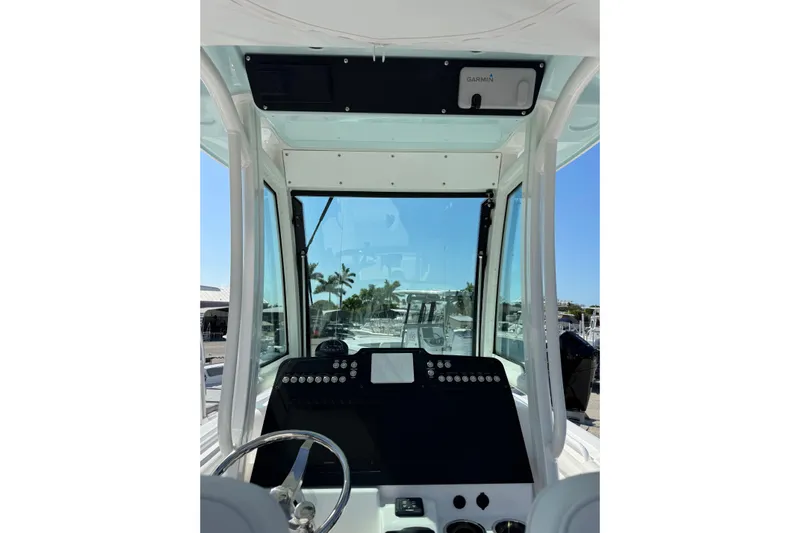  Yacht Photos Pics 2024 Everglades 235 Center Console boat dashboard with steering wheel and navigation equipment.