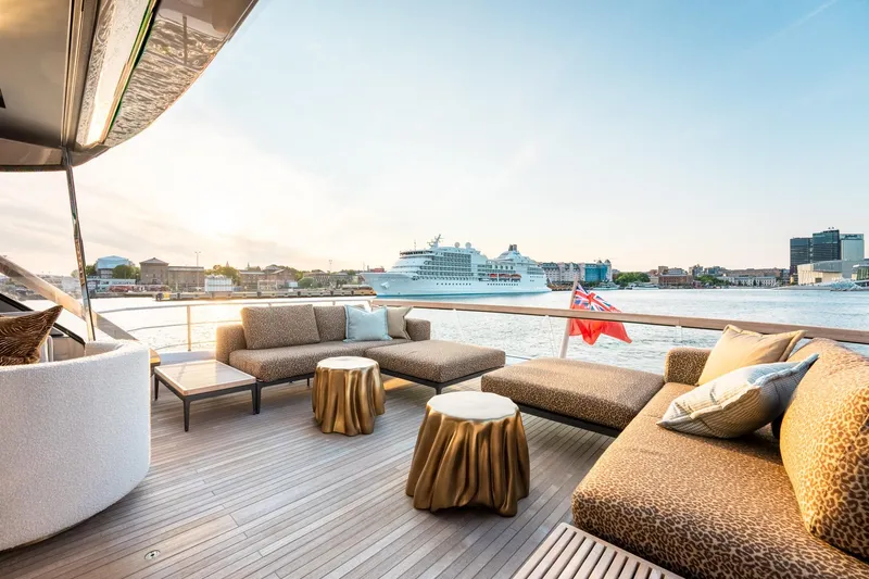 North Yacht Photos Pics Luxurious Sanlorenzo SX88 yacht deck with elegant seating, overlooking a scenic harbor view.