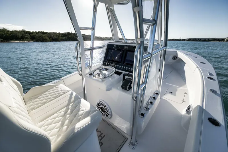  Yacht Photos Pics 2025 Conch 27 boat interior with modern helm, luxurious seating, and scenic water view.
