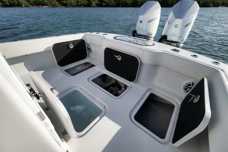  Yacht Photos Pics 2025 Conch 27 boat with open storage compartments and dual Mercury engines on water.