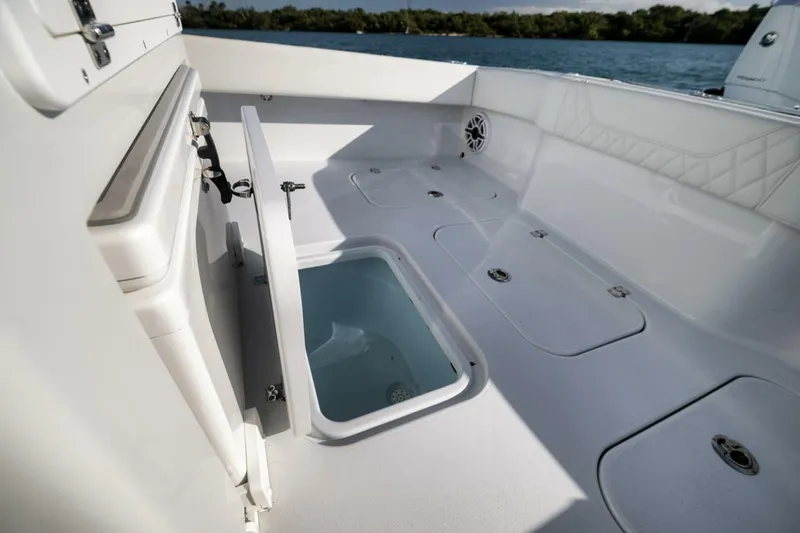  Yacht Photos Pics 2025 Conch 27 boat interior with open storage compartments and seating, near water.