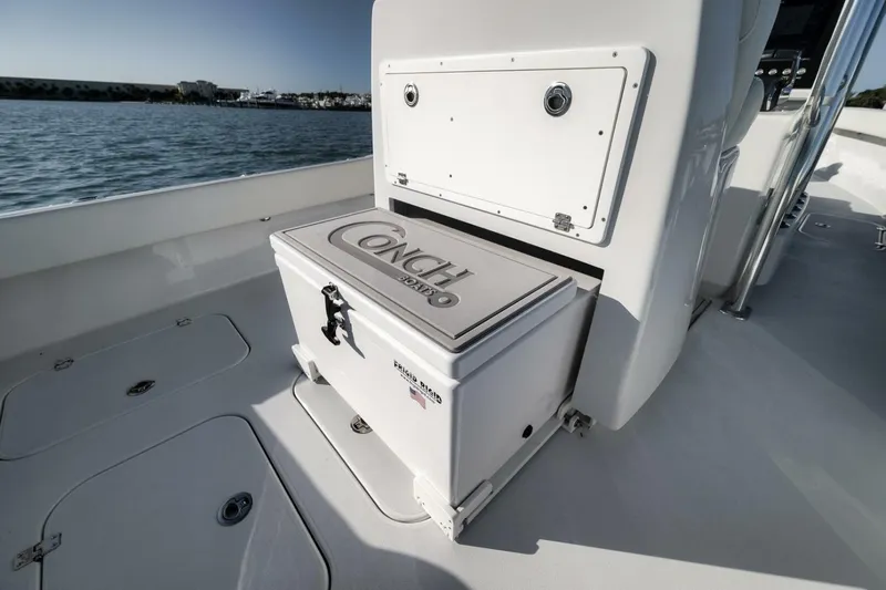  Yacht Photos Pics 2025 Conch 27 boat interior with storage compartment, ocean view in background.