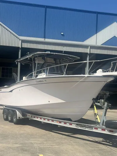  Yacht Photos Pics 2003 Grady-White 306 Bimini boat on trailer, parked outside a blue industrial building.