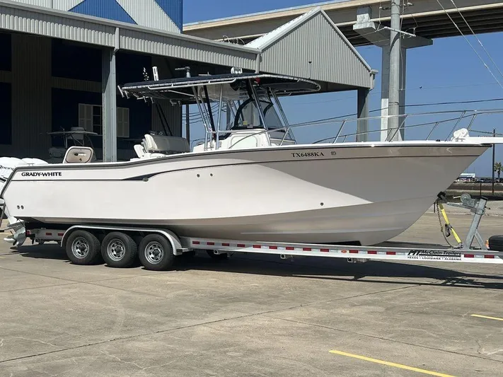  Yacht Photos Pics 2003 Grady-White 306 Bimini boat on trailer, parked near a marina.