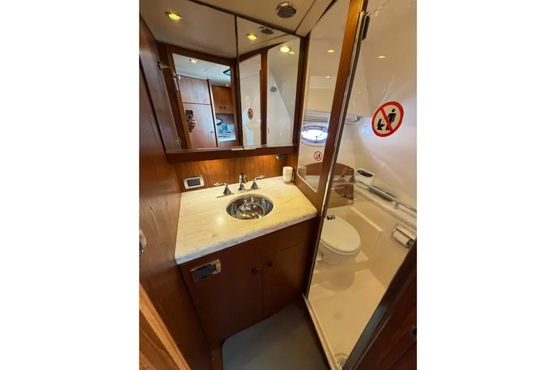 Loophole Yacht Photos Pics 2013 Tiara Yachts 3600 Coronet bathroom with sink, mirror, and toilet in compact space.