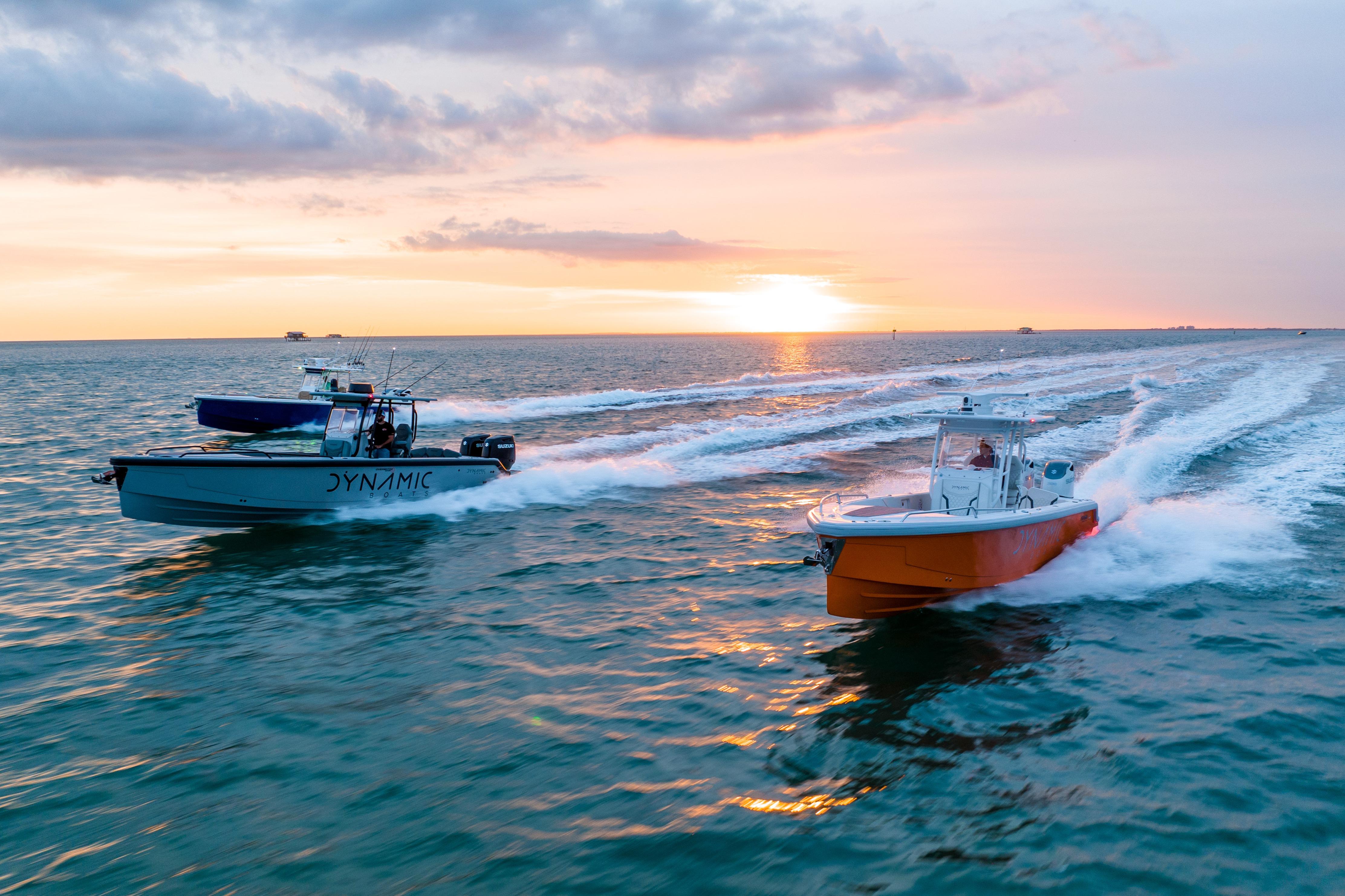 Two Dynamic D-305V boats racing at sunset on the ocean, 2024 model.