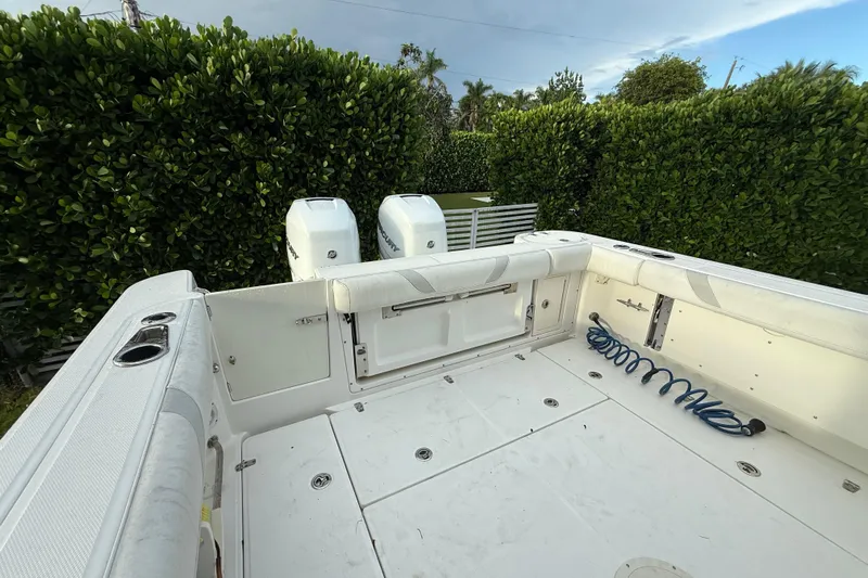  Yacht Photos Pics 2011 Boston Whaler 285 Conquest boat deck with twin engines and lush greenery backdrop.