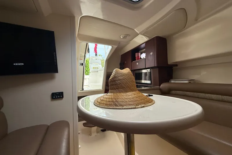  Yacht Photos Pics Interior of 2011 Boston Whaler 285 Conquest with table, hat, and seating area.