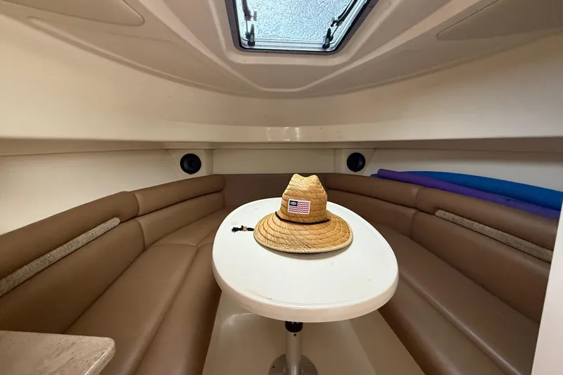 Yacht Photos Pics 2011 Boston Whaler 285 Conquest cabin interior with table, seating, and straw hat.