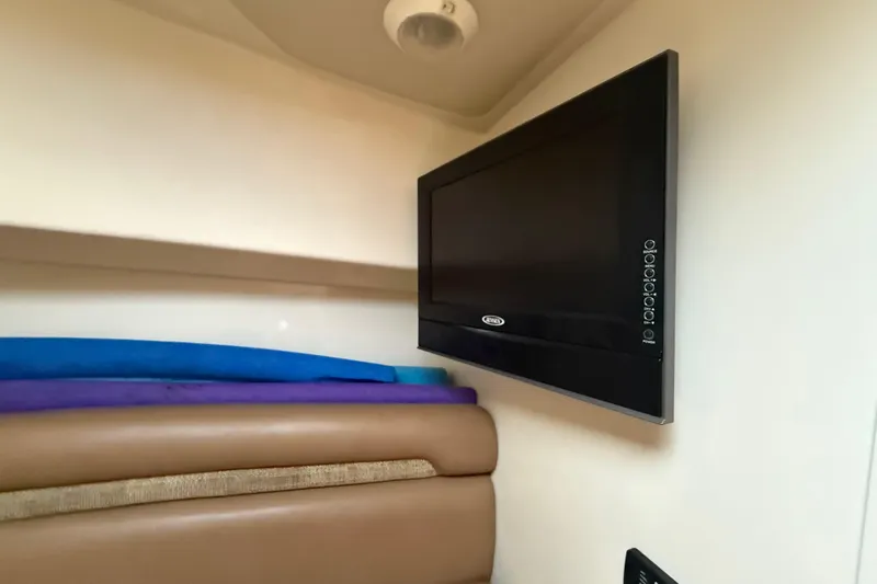  Yacht Photos Pics 2011 Boston Whaler 285 Conquest cabin interior with mounted TV and seating.