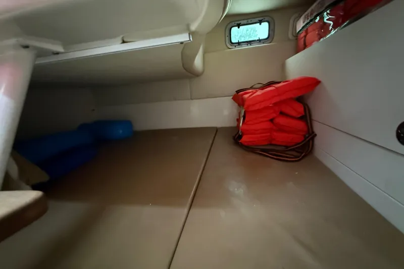  Yacht Photos Pics 2011 Boston Whaler 285 Conquest cabin interior with life jackets and storage space.