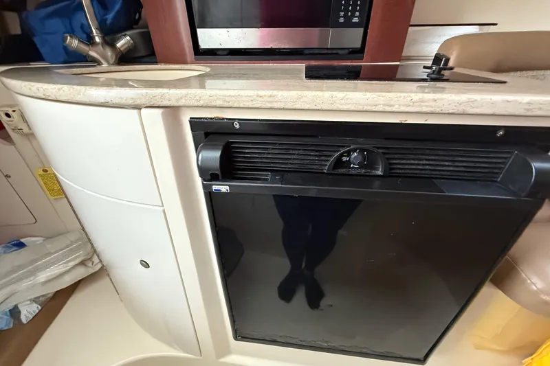  Yacht Photos Pics 2011 Boston Whaler 285 Conquest interior with kitchenette, featuring sink, microwave, and fridge.