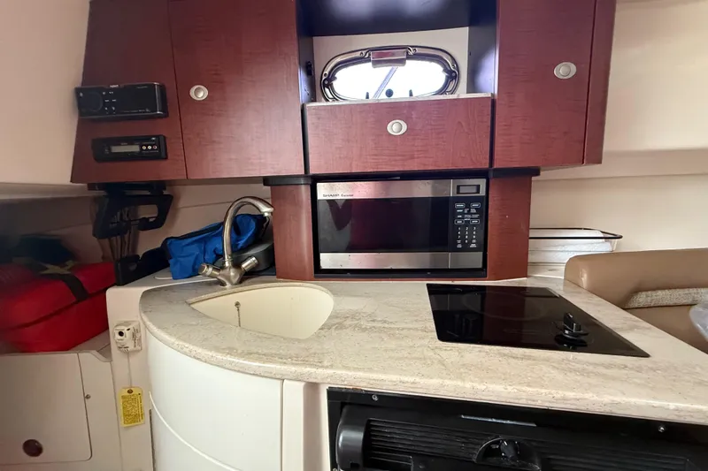  Yacht Photos Pics Interior of 2011 Boston Whaler 285 Conquest with kitchenette, microwave, and sink.