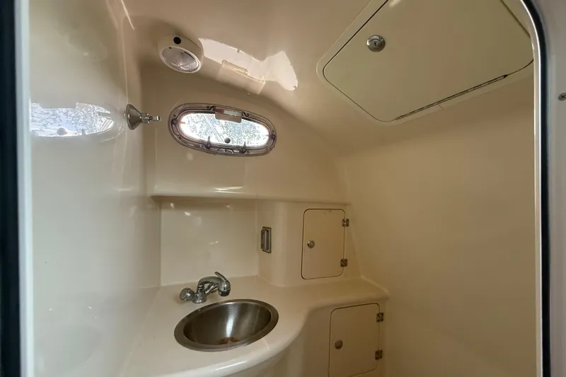  Yacht Photos Pics 2011 Boston Whaler 285 Conquest cabin interior with sink and storage compartments.