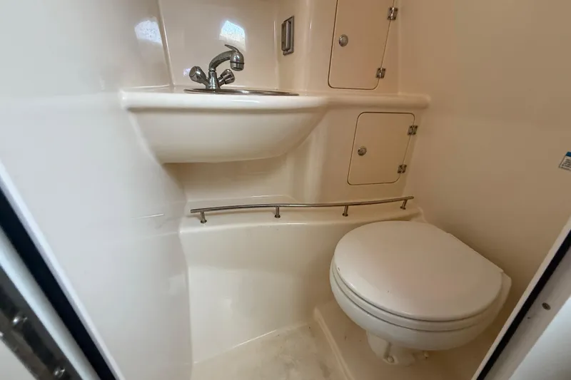  Yacht Photos Pics Compact bathroom in 2011 Boston Whaler 285 Conquest boat, featuring sink and toilet.