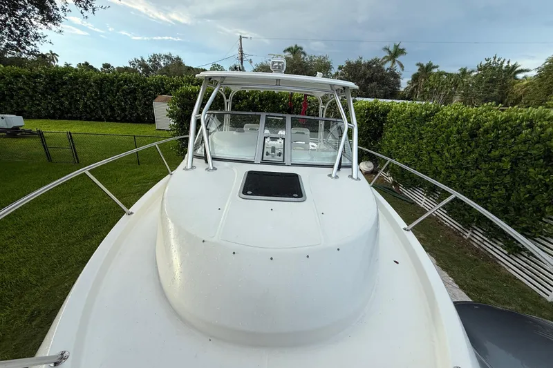  Yacht Photos Pics 2011 Boston Whaler 285 Conquest boat docked in a lush, green backyard setting.