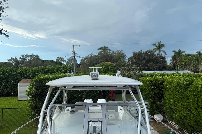  Yacht Photos Pics 2011 Boston Whaler 285 Conquest boat in a lush, green backyard setting.