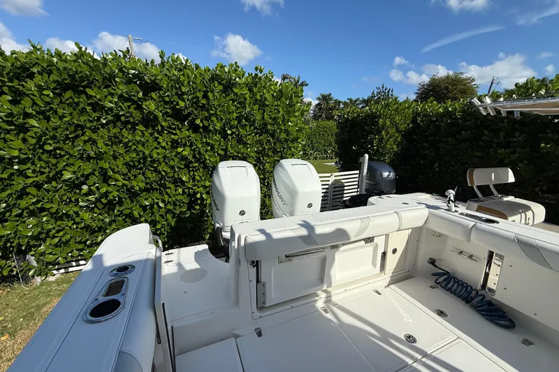  Yacht Photos Pics 2011 Boston Whaler 285 Conquest boat deck with dual engines, surrounded by lush greenery.