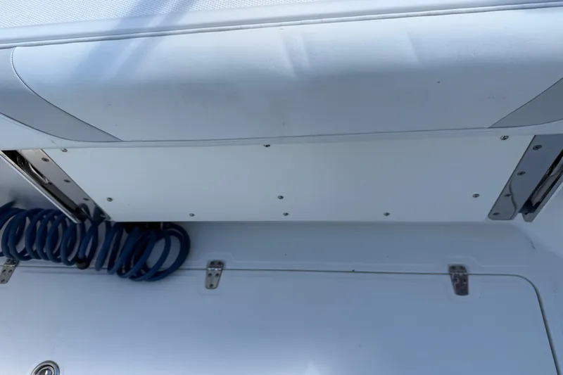  Yacht Photos Pics 2011 Boston Whaler 285 Conquest boat interior with coiled blue hose and storage compartment.