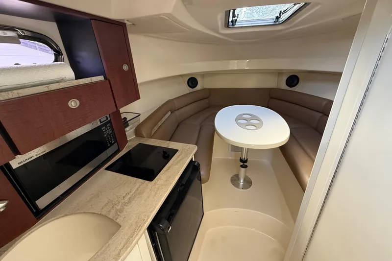  Yacht Photos Pics Interior of 2011 Boston Whaler 285 Conquest with seating, table, and kitchenette.