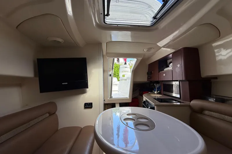  Yacht Photos Pics Interior of 2011 Boston Whaler 285 Conquest boat with seating, table, and kitchenette.