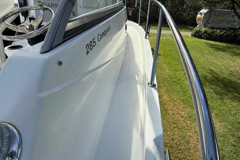  Yacht Photos Pics 2011 Boston Whaler 285 Conquest boat deck with railing, parked on grass.