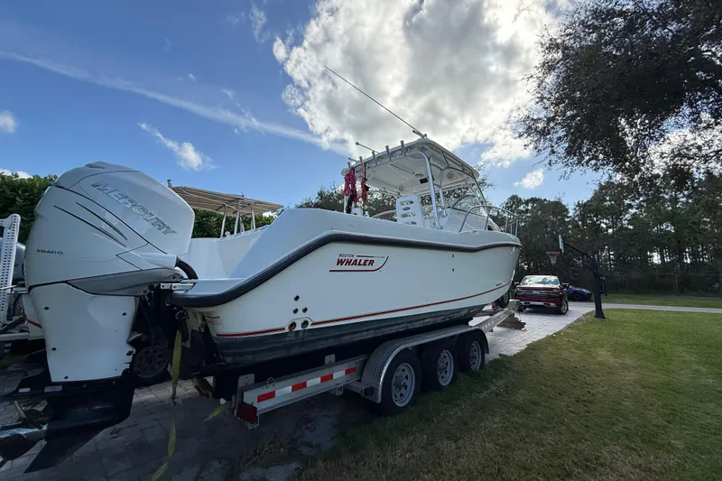  Yacht Photos Pics 2011 Boston Whaler 285 Conquest boat on trailer with Mercury engines, parked outdoors.
